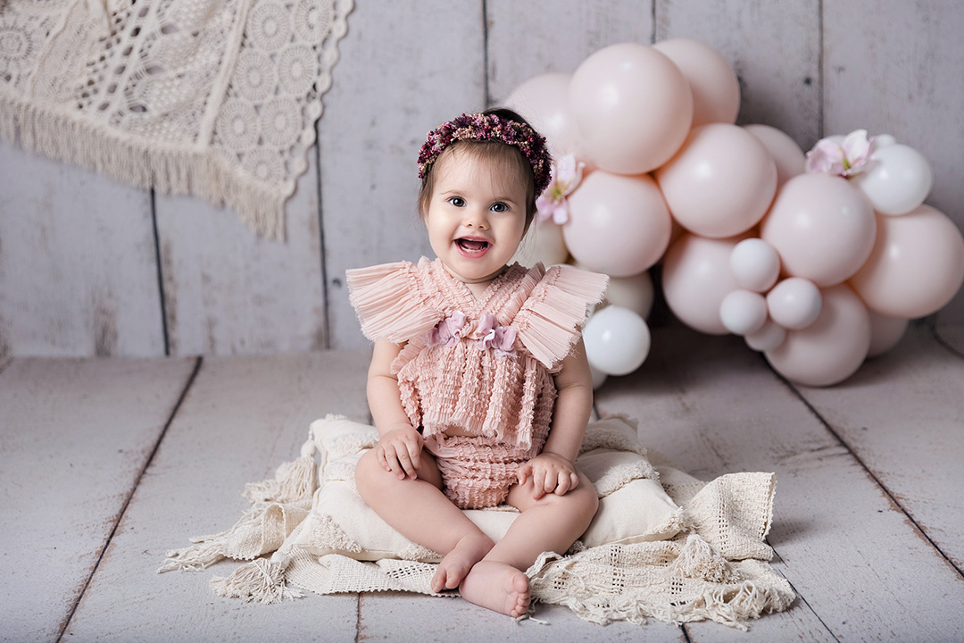 Photographie de bébé avec des ballons roses