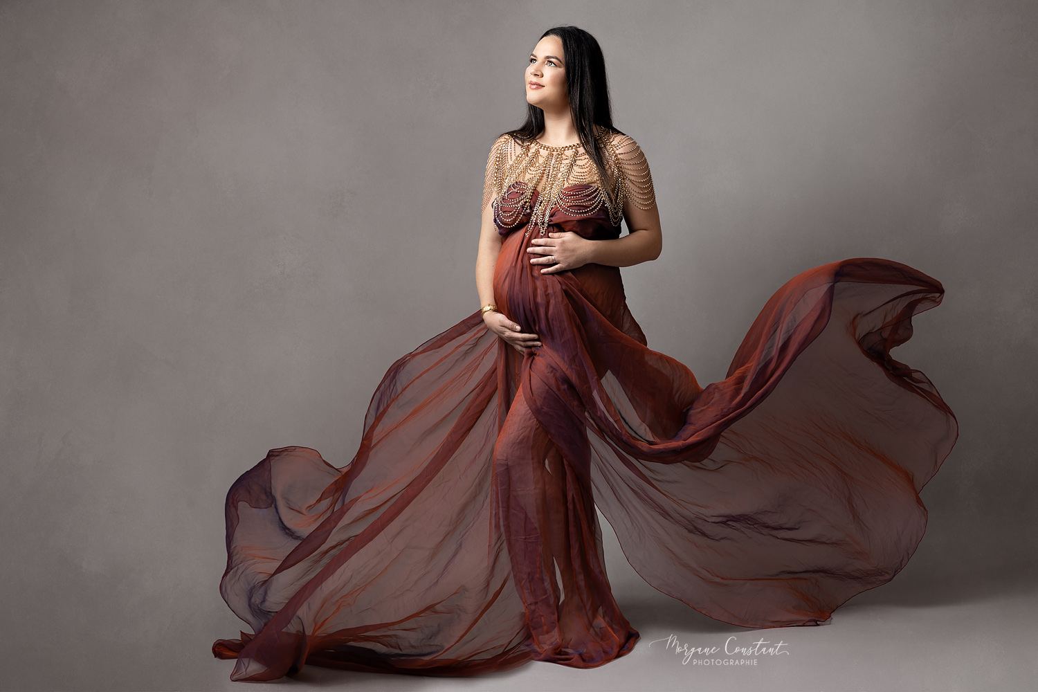 femme enceinte avec un voilage rouge qui flotte autour d'elle